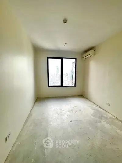 Spacious empty room with large window and city view, perfect for customization.