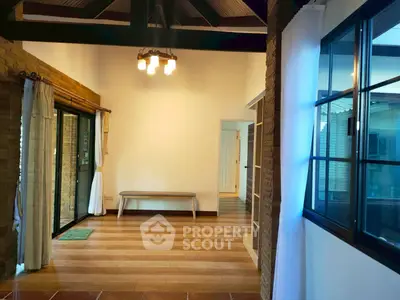 Spacious interior with wooden flooring and large windows, perfect for natural light lovers.