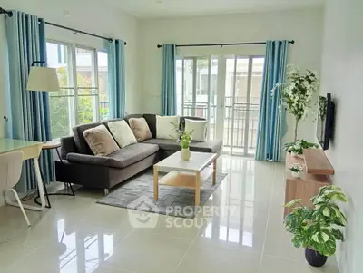 Bright and spacious living room with modern decor and large windows leading to a balcony.