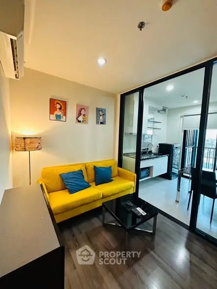 Modern living room with vibrant yellow sofa and open kitchen layout