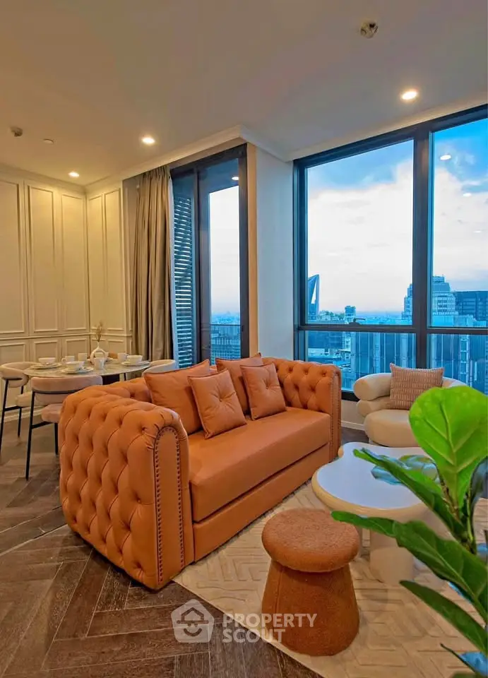 Luxurious living room with stunning city view, elegant decor, and plush seating in a high-rise apartment.
