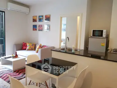 Modern open-plan living room with stylish decor and compact kitchen area