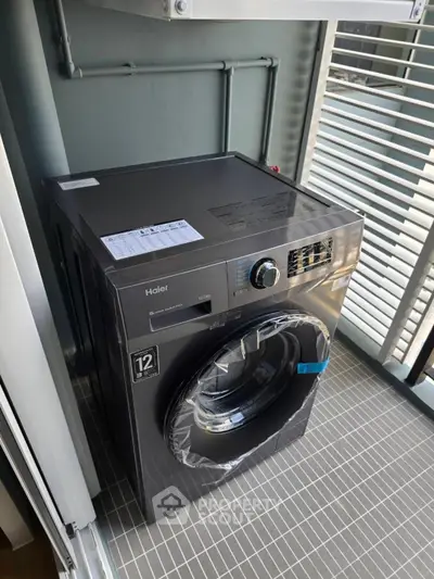 Modern washing machine on tiled balcony with sleek design and efficient features.