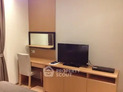 Modern bedroom with sleek TV setup and stylish desk area