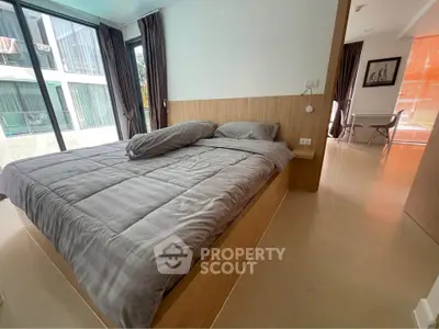 Modern bedroom with large windows and stylish decor in a contemporary apartment.