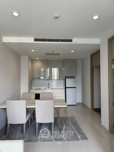 Modern open-plan kitchen and dining area with sleek design and neutral tones.