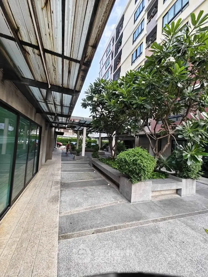 Modern building entrance with lush greenery and sleek design