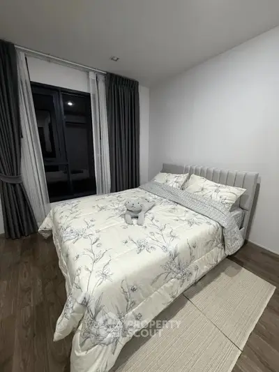 Cozy bedroom with elegant bedding and large window in modern apartment