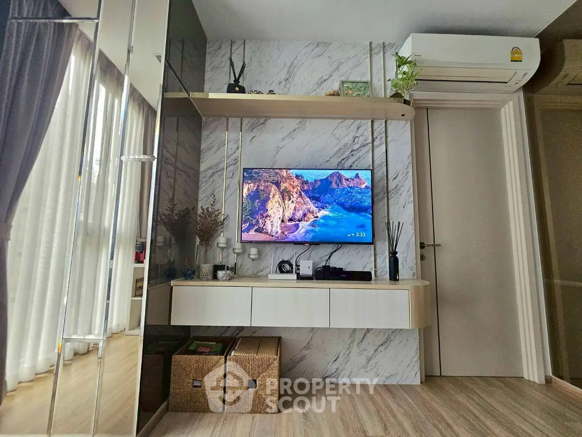 Modern living room with stylish decor and wall-mounted TV, featuring elegant marble accents and cozy atmosphere.