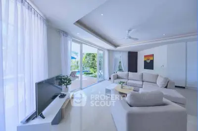 Spacious living room with modern decor and pool view, perfect for relaxation and entertainment.