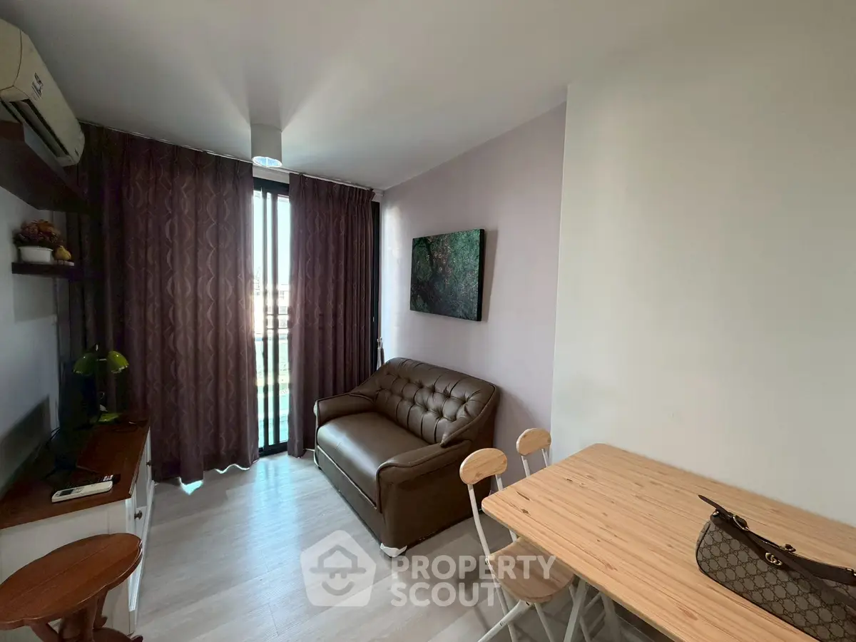 Cozy living room with modern decor and natural light, featuring a leather sofa and dining area.