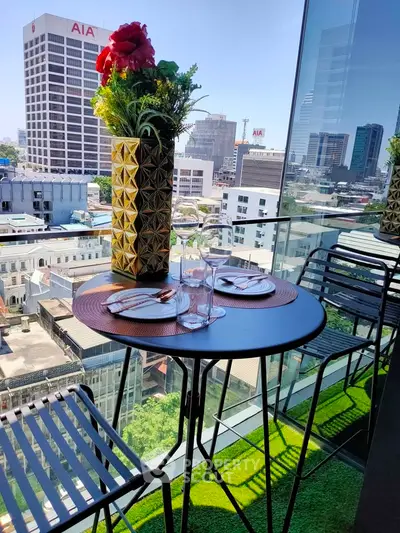 Stunning city view from a modern balcony with elegant outdoor dining setup.