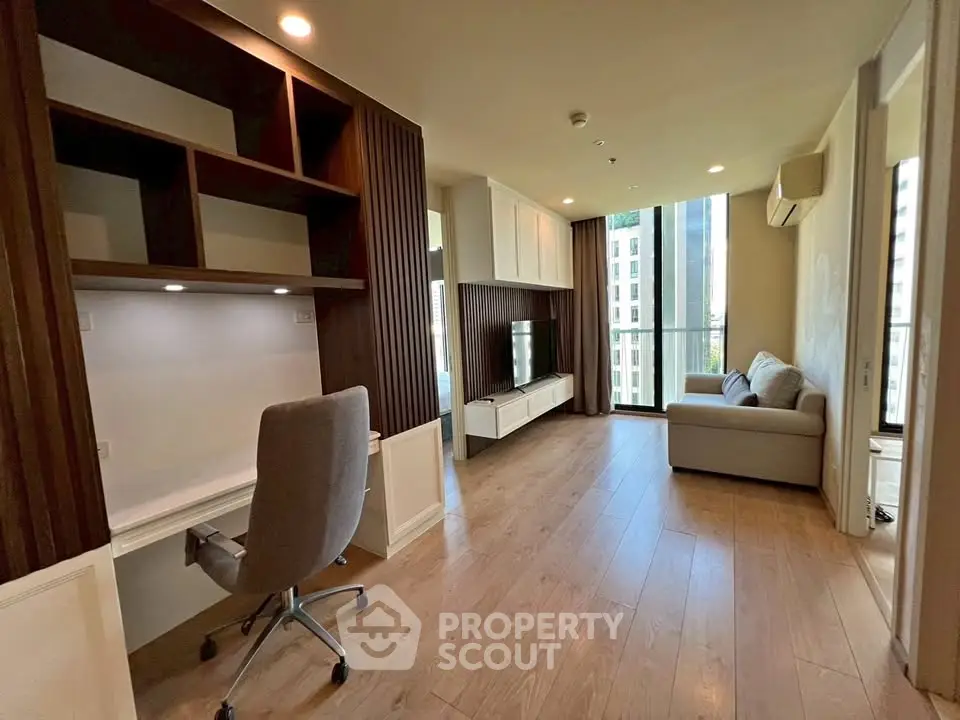 Modern living room with study area, featuring sleek wooden flooring and a cozy sofa, perfect for urban living.