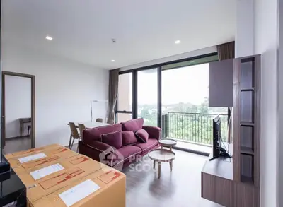 Modern living room with large windows and scenic view, featuring stylish furniture and open layout.