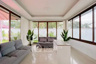 Spacious living room with large windows and modern furniture, offering a bright and airy atmosphere.
