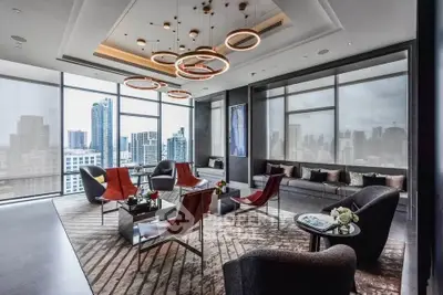 Luxurious modern living room with stunning city skyline view and elegant lighting fixtures.