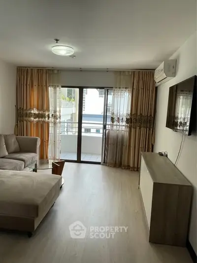 Spacious living room with modern decor and balcony access