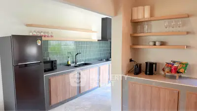 Modern kitchen with sleek appliances and open shelving, featuring a gas stove and ample counter space.
