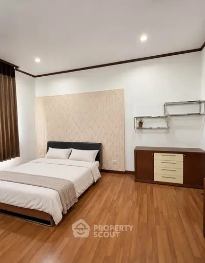 Spacious bedroom with modern decor and wooden flooring
