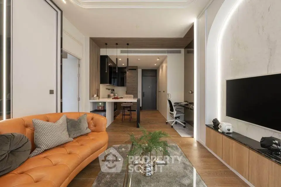 Modern living room with stylish decor and open kitchen layout, featuring a cozy orange sofa and sleek wooden flooring.