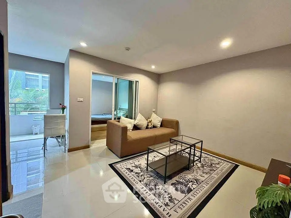 Modern living room with stylish decor and open layout, featuring a cozy sofa and glass coffee table.