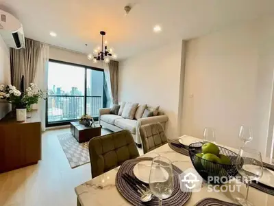 Elegant open-plan living space with a plush sofa set, chic dining area, and access to a sunlit balcony offering an urban view, perfect for modern living.