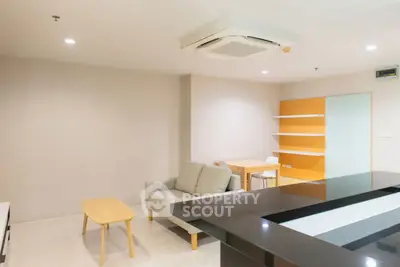 Modern living room with sleek furniture and open layout, featuring a cozy sofa and stylish dining area.