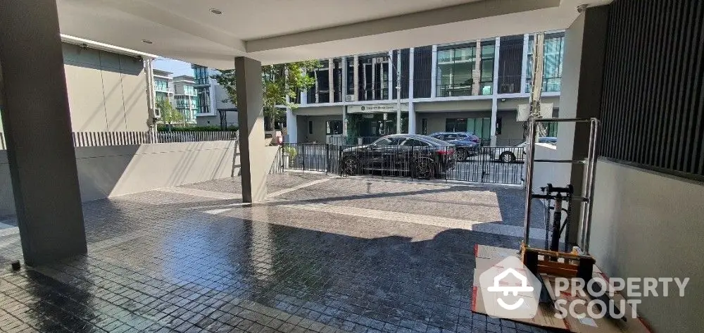 Spacious covered parking area in a modern residential building with secure gated entry and well-maintained, clean surroundings.