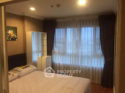 Cozy bedroom with large window and elegant curtains in modern apartment