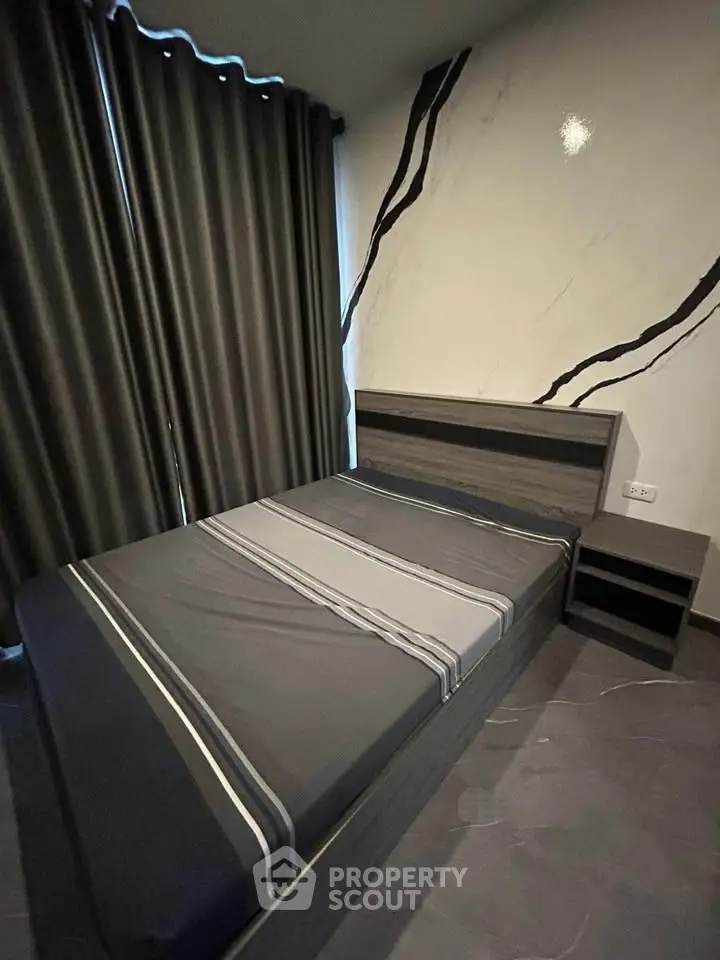 Modern bedroom with stylish decor and sleek furniture, featuring a comfortable bed and elegant curtains.