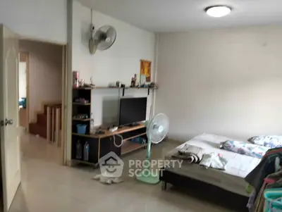 Cozy bedroom with TV and fan, ideal for comfortable living.