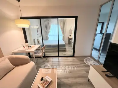 Modern studio apartment with cozy living area and bedroom separated by glass doors.