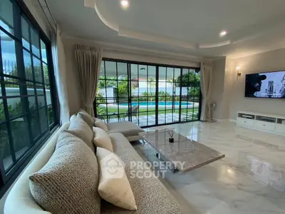Luxurious living room with pool view, elegant sofa, and marble flooring in modern home.