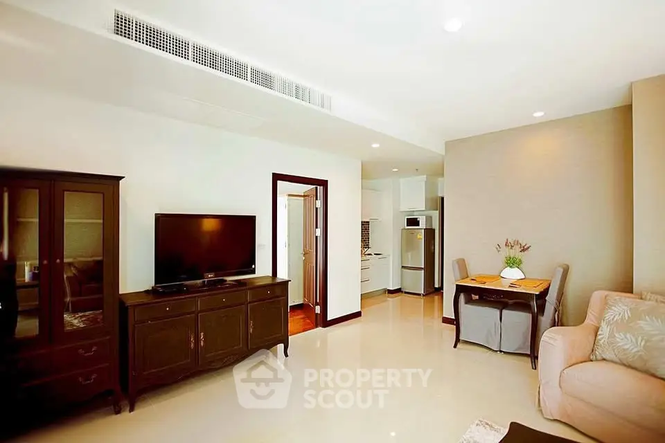 Spacious living room with elegant furniture and modern kitchen in open layout apartment.