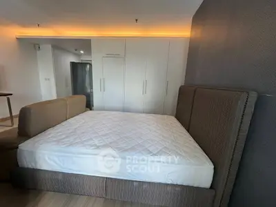 Spacious bedroom with modern design featuring a large bed and ample closet space.