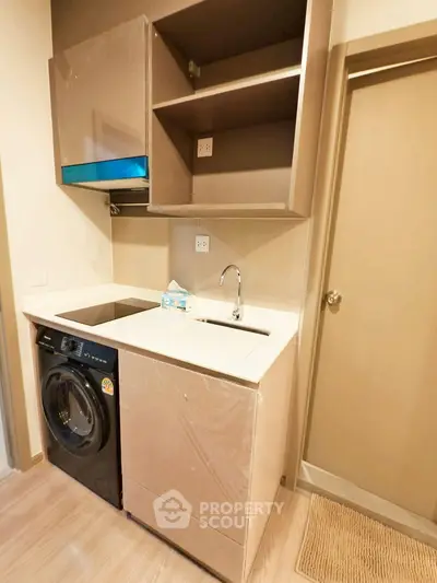 Compact kitchen with washing machine and modern cabinetry