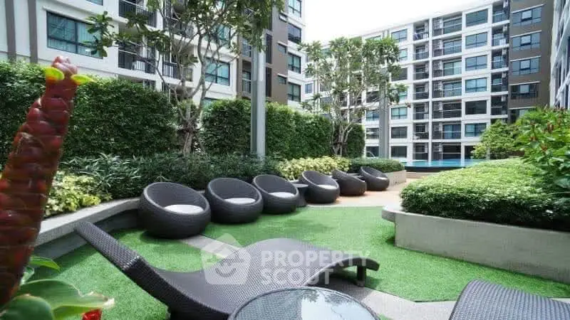 Modern apartment complex with lush garden and stylish outdoor seating area.