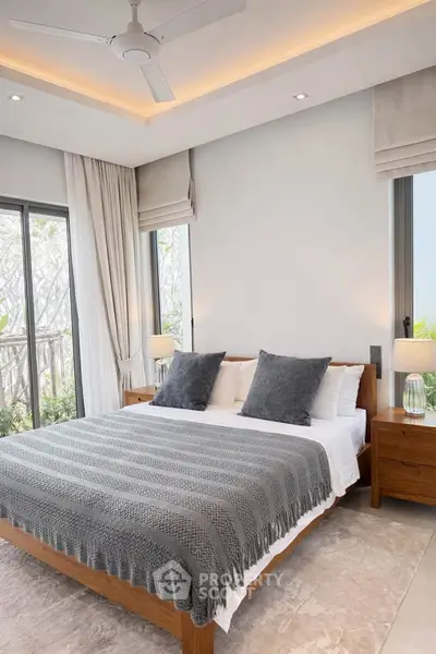 Luxurious bedroom with modern decor and large windows offering natural light