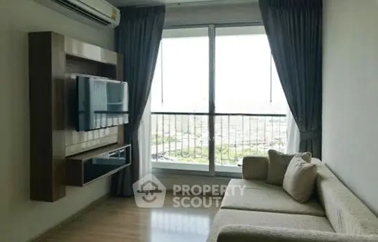 Modern living room with large window and stylish furniture in high-rise apartment.