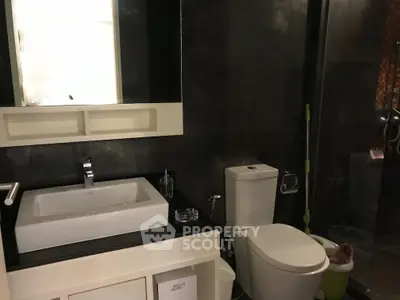 Modern bathroom with sleek fixtures and dark tile design