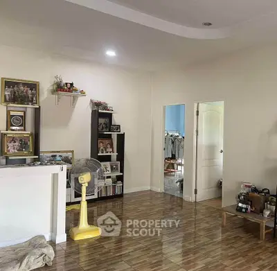Spacious living room with stylish decor and wooden flooring, perfect for family gatherings.