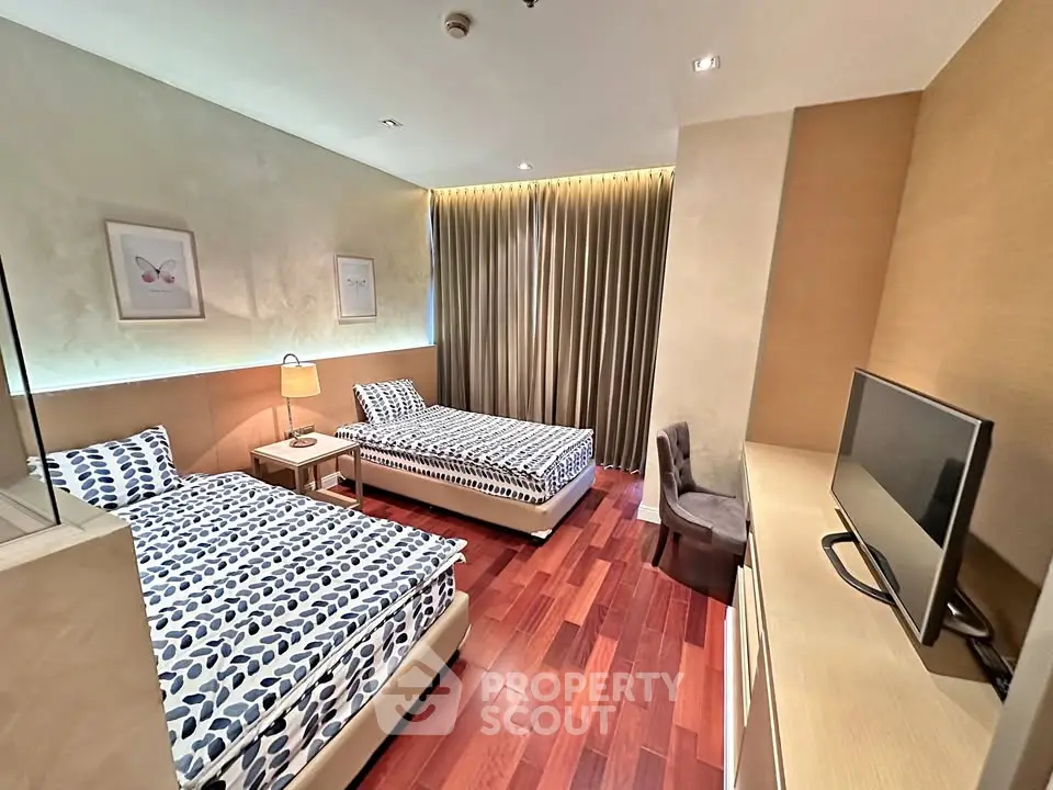 Spacious bedroom with twin beds and modern decor, perfect for comfortable living.