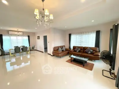 Spacious living room with elegant chandelier and modern furniture in a bright open layout.