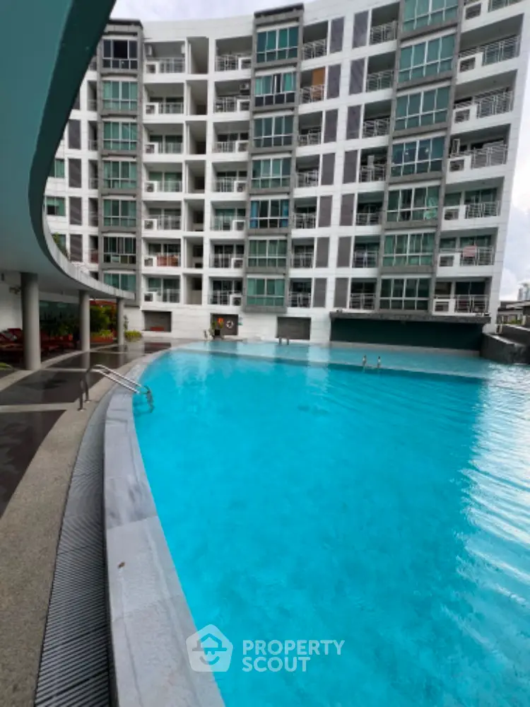 Luxurious residential building with stunning pool view and modern architecture.