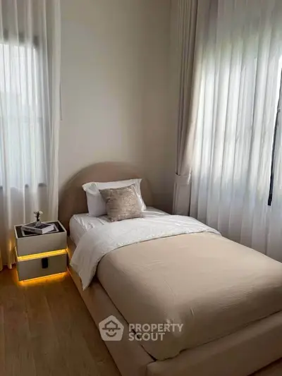 Cozy bedroom with elegant single bed and soft lighting, perfect for relaxation.