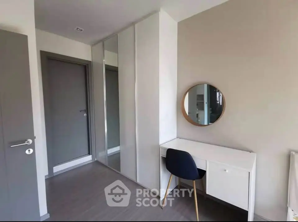 Modern study room with sleek desk, chair, and mirrored wardrobe in minimalist design.
