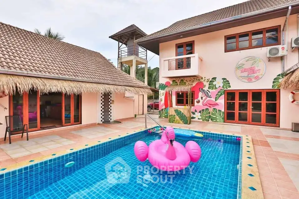 Tropical villa with vibrant pool and flamingo decor, perfect for luxurious relaxation.