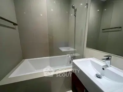 Modern bathroom with sleek bathtub and elegant sink in contemporary apartment.