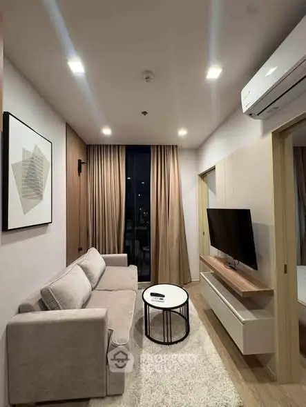 Modern living room with cozy sofa, wall-mounted TV, and elegant decor in a stylish apartment.