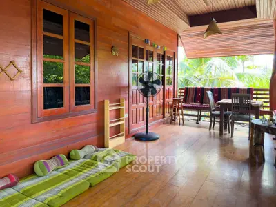 Charming wooden balcony with cozy seating and lush garden view, perfect for relaxation and entertaining.
